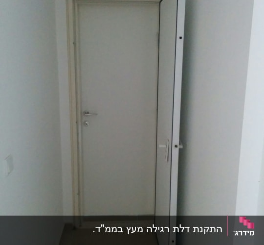 דלת לבנה פתוחה למחצה עם ידית מתכת